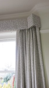 Straight pelmet with pop pom trim in bay window. Morris and Co Pure fabric